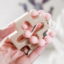Load image into Gallery viewer, Hand holding pink and pearl silicone bead rosary teether
