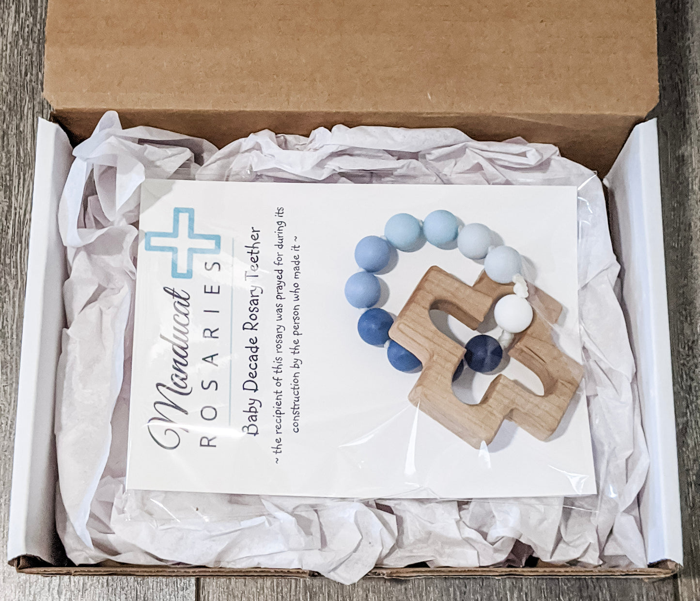 Catholic teething ring in packaging stating baby was prayed for during item's construction