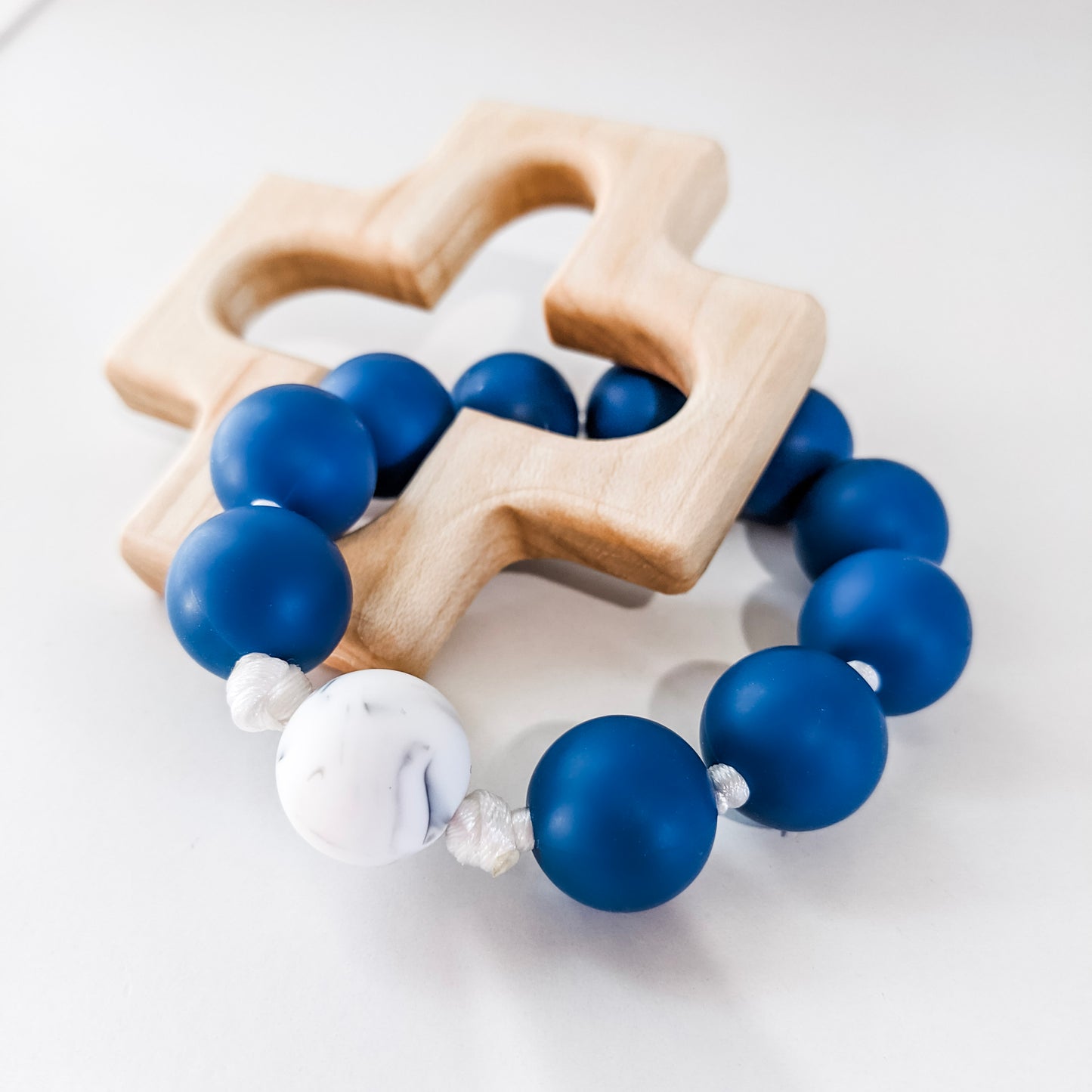 Blue and white marble silicone teething ring with wooden cross teether