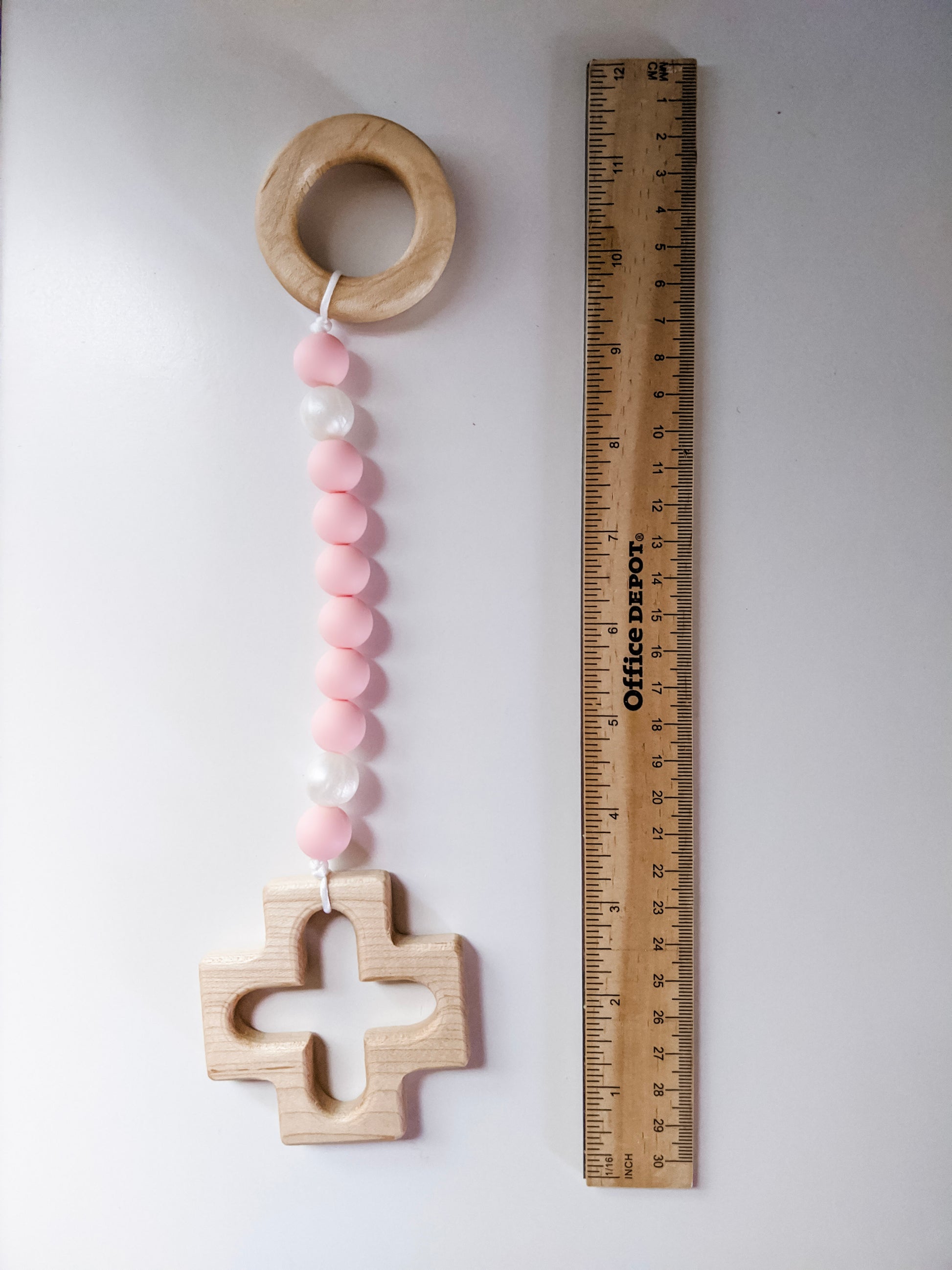 Pink silicone rosary strand next to ruler showing dimensions