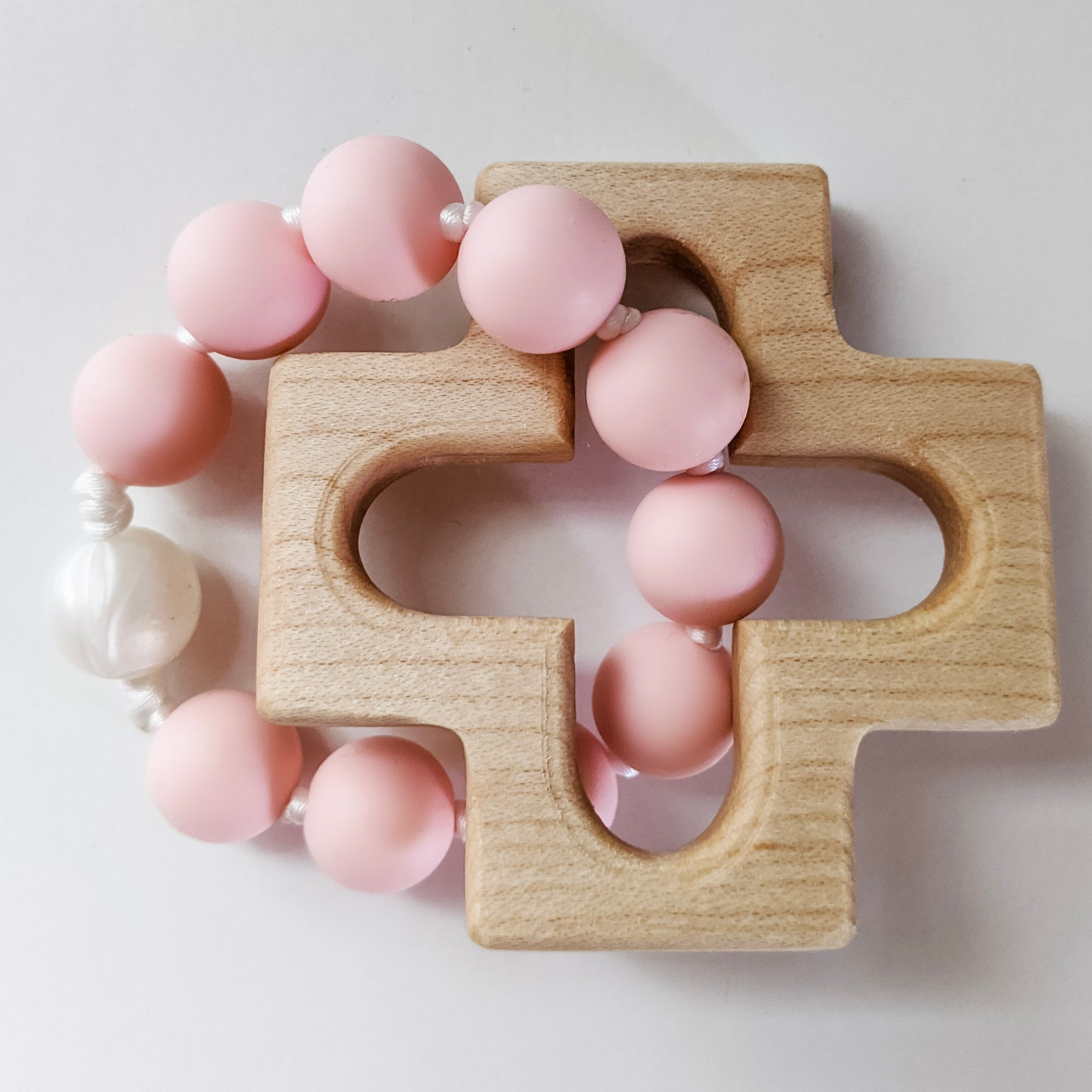 Pink and Pearl silicone bead ring through wooden cross teether