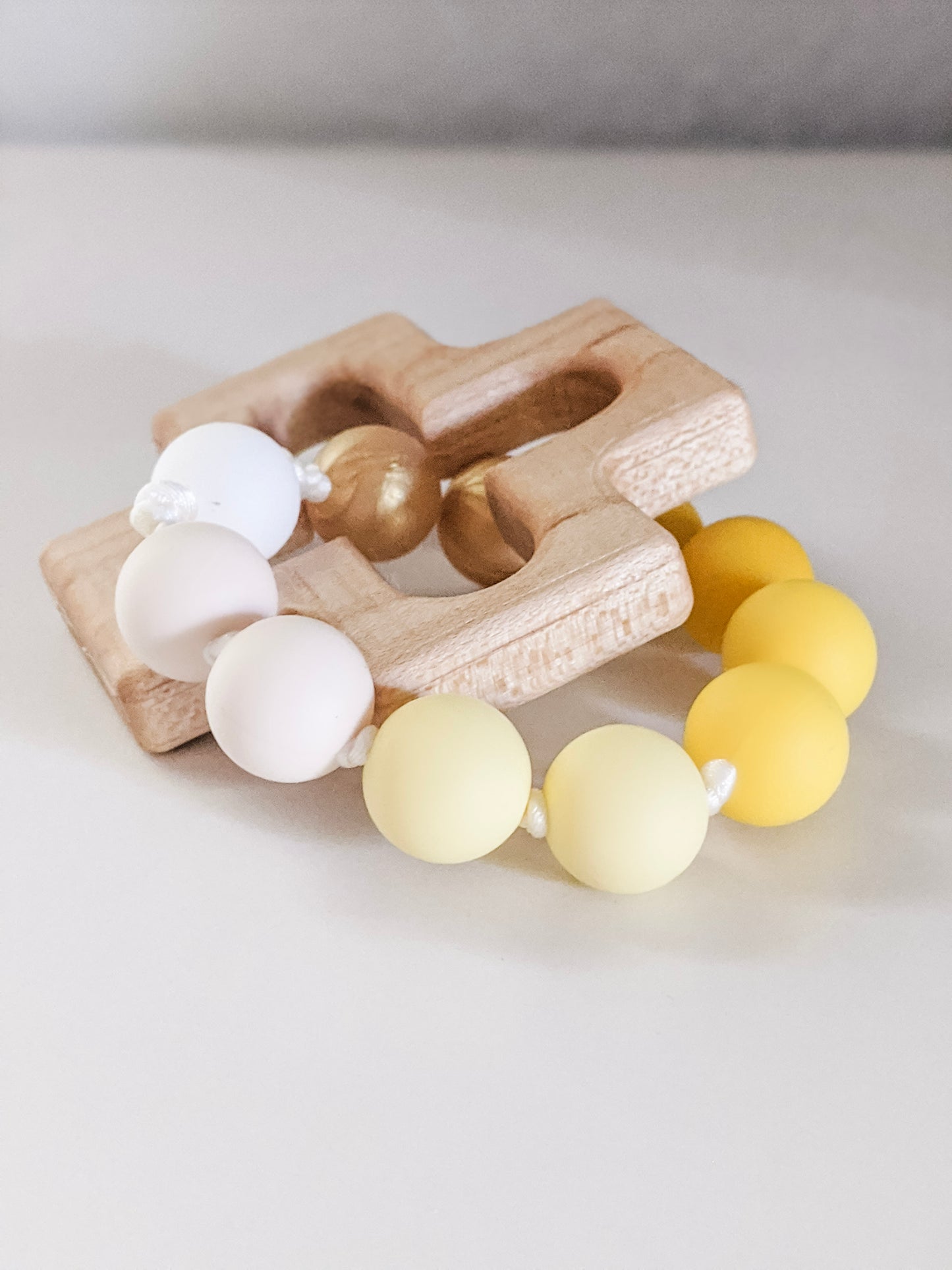 Yellow ombre Catholic Baptism gift: silicone teething ring through wooden cross teether