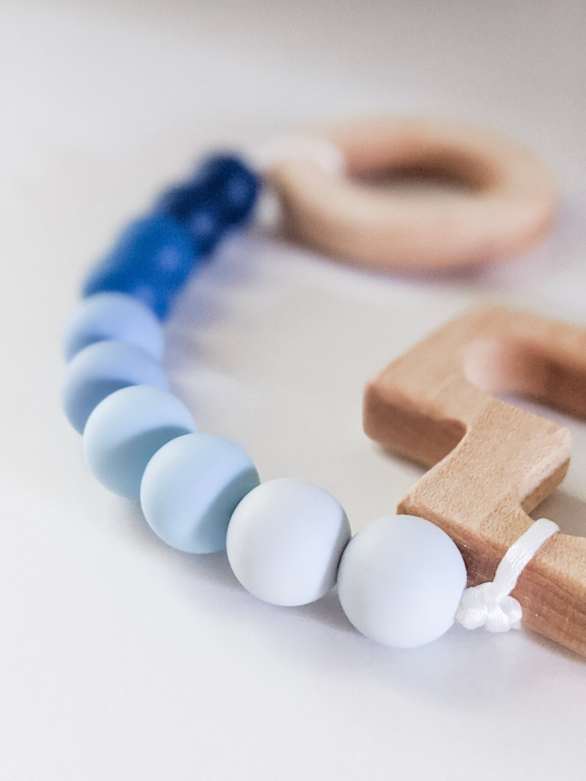 Close up of light blue in blue ombre rosary teething strand