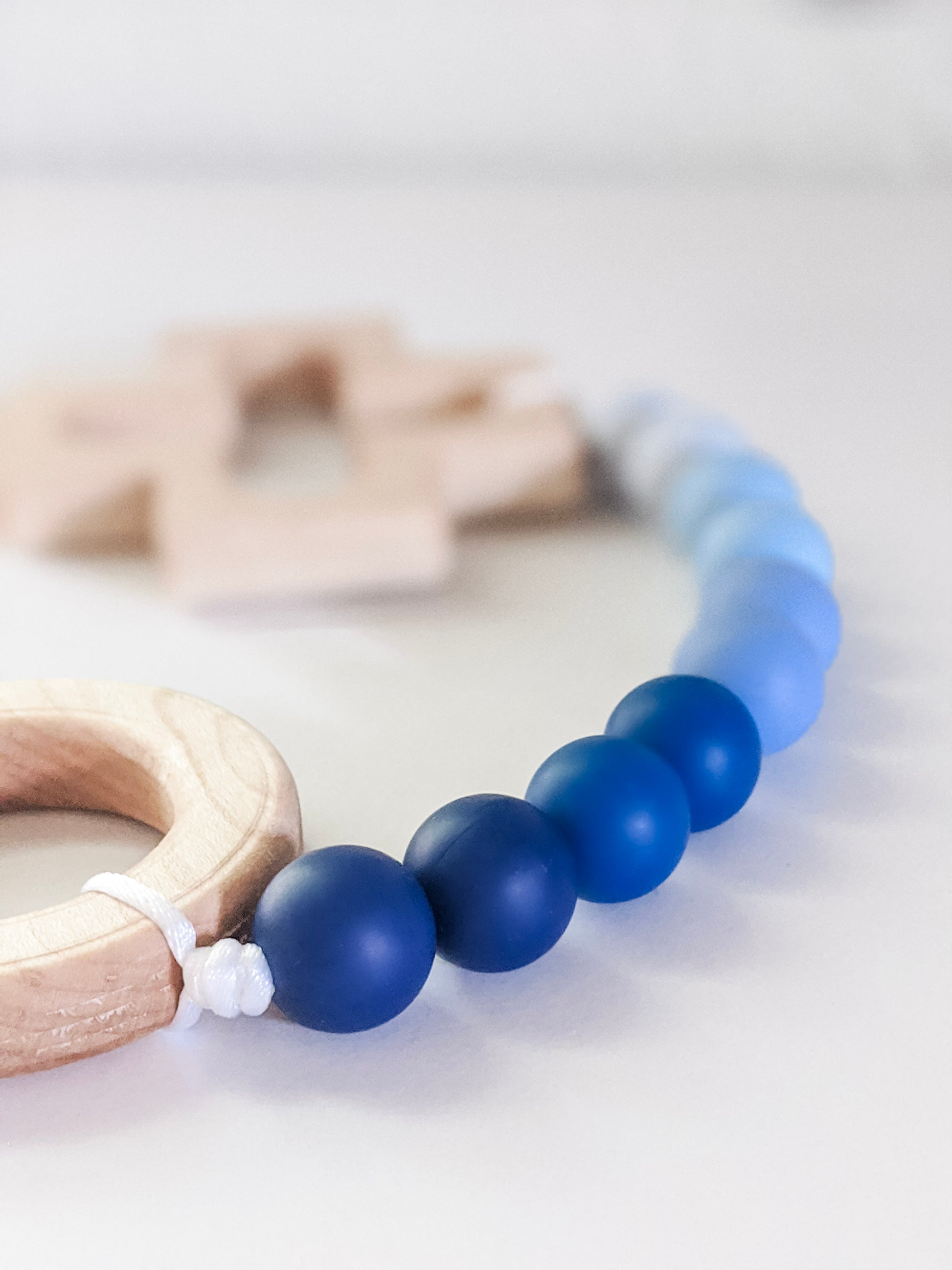 Close up of dark blue in blue ombre rosary teething strand