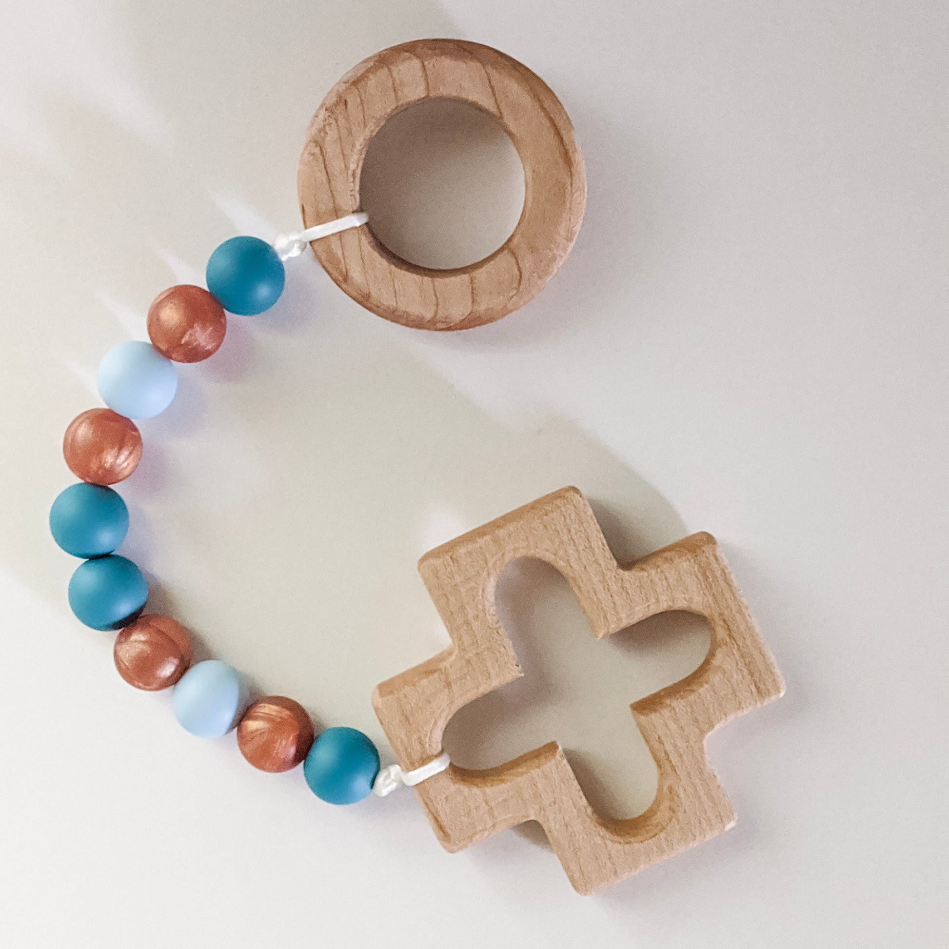 Silicone bead teething strand with wooden ring and cross at either end