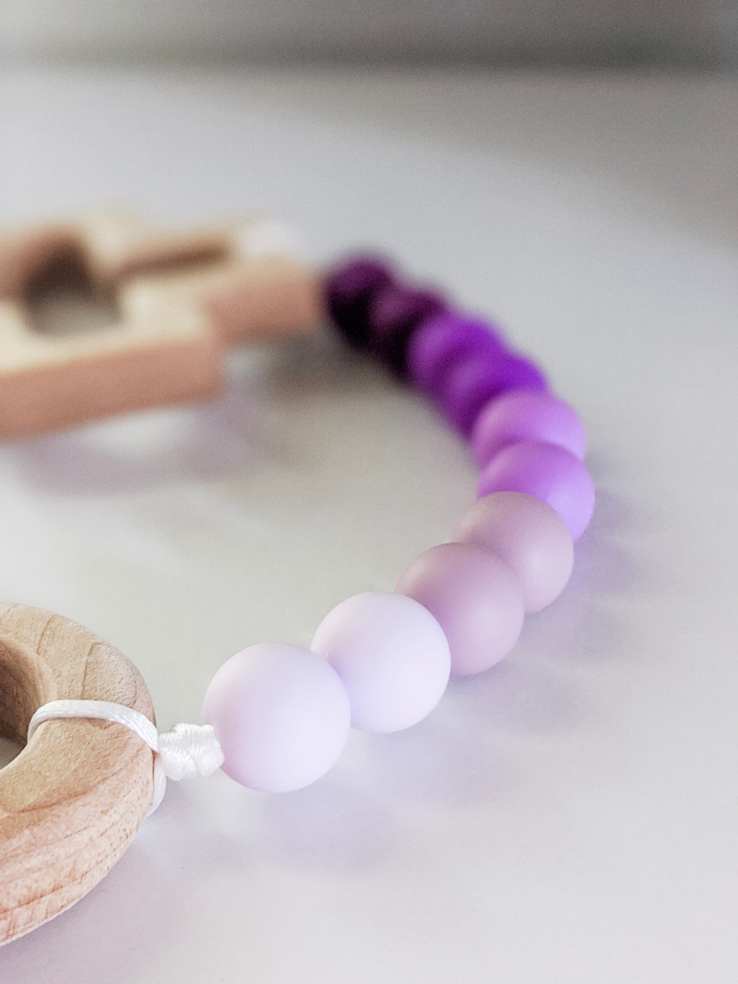 Close up of light colored purple in ombre decade rosary teething strand