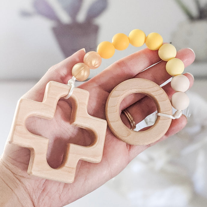 Hand holding yellow ombre teething rosary strand